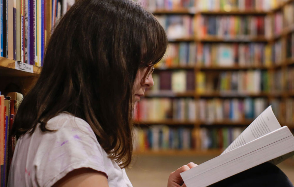 young lady reading in the library