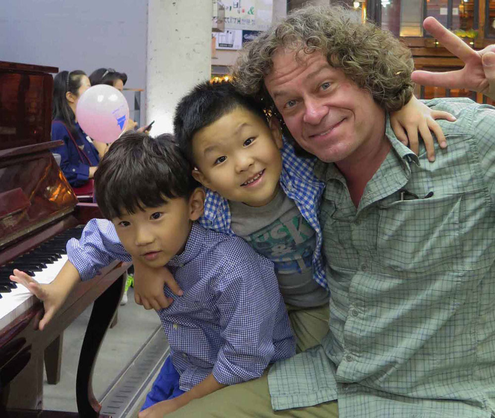 Frank Peter at the piano with young Korean boys